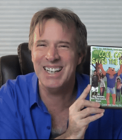 A Man In A Blue Shirt Is Smiling And Holding A Cool Cat Saves The Kid Dvd GIF