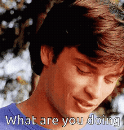 A Man In A Blue Shirt Is Smiling And Says What Are You Doing GIF