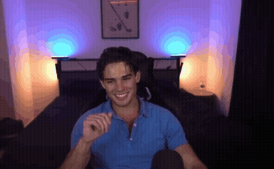 A Man In A Blue Shirt Is Smiling In Front Of A Wall With A Picture Of Golf Clubs On It GIF