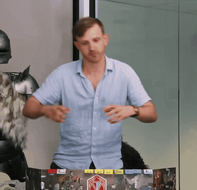 A Man In A Blue Shirt Is Standing In Front Of A Board With A Sticker That Says ' A ' On It GIF