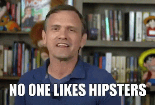 A Man In A Blue Shirt Is Standing In Front Of A Bookshelf And Says No One Likes Hipsters GIF