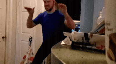 A Man In A Blue Shirt Is Standing In Front Of A Box That Says 2 Lb GIF