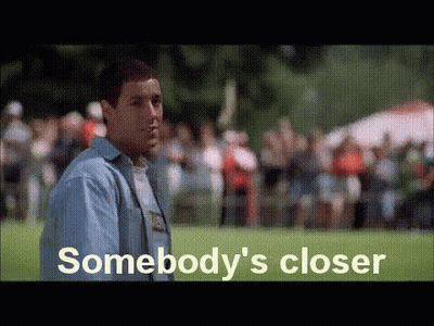 A Man In A Blue Shirt Is Standing In Front Of A Crowd Of People . GIF