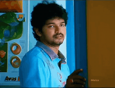 A Man In A Blue Shirt Is Standing In Front Of A Door With The Word Avas On It GIF