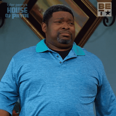 A Man In A Blue Shirt Is Standing In Front Of A Framed Picture That Says House Of Payne GIF