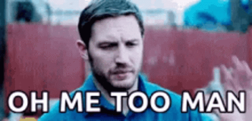 A Man In A Blue Shirt Is Standing In Front Of A Red Wall And Saying `` Oh Me Too Man '' . GIF