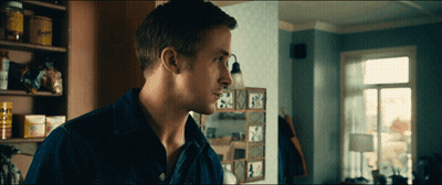 A Man In A Blue Shirt Is Standing In Front Of A Shelf With A Sign That Says ' A ' GIF