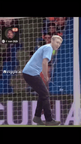 A Man In A Blue Shirt Is Standing In Front Of A Soccer Net With The Number 4 On It GIF