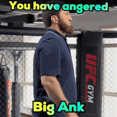 A Man In A Blue Shirt Is Standing In Front Of A Ufc Gym GIF