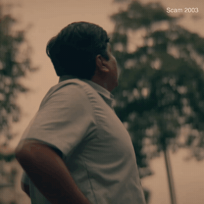 A Man In A Blue Shirt Is Standing In Front Of Trees And The Year 2003 Is On The Bottom GIF