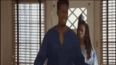 A Man In A Blue Shirt Is Standing Next To A Woman In A Blue Dress GIF
