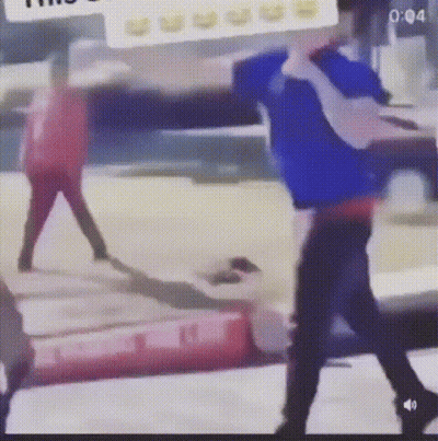 A Man In A Blue Shirt Is Standing Next To A Woman In A Red Shirt In A Blurry Photo . GIF
