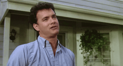 A Man In A Blue Shirt Is Standing On A Porch GIF