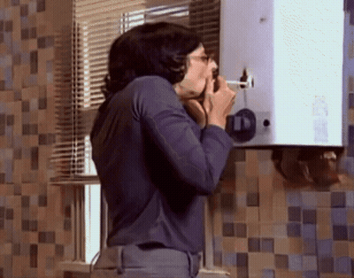 A Man In A Blue Shirt Is Talking On A Phone In Front Of A Wall With A Number 11 On It GIF