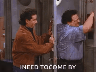 A Man In A Blue Shirt Is Talking To Another Man In A Brown Jacket . GIF