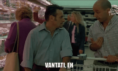 A Man In A Blue Shirt Is Talking To Another Man In A Grocery Store And Says Vantati Eh GIF