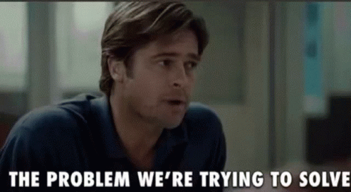 A Man In A Blue Shirt Is Talking To Another Man In A Room . GIF