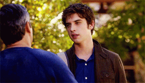 A Man In A Blue Shirt Is Talking To Another Man GIF