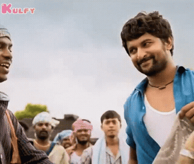 A Man In A Blue Shirt Is Talking To Another Man GIF