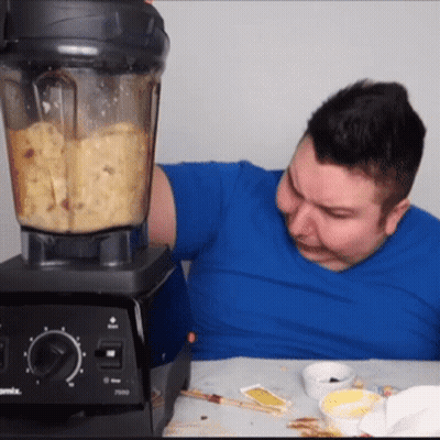 A Man In A Blue Shirt Is Using A Vitamix Blender To Make Food GIF