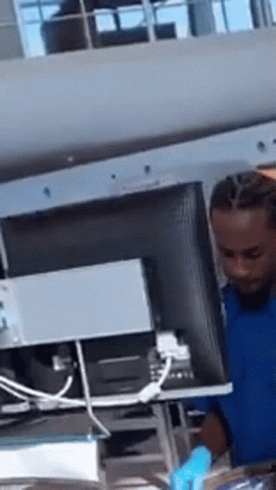 A Man In A Blue Shirt Is Working On A Computer . GIF