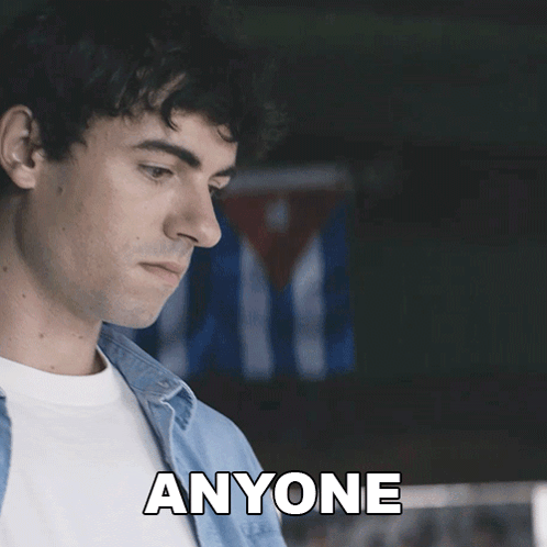 A Man In A Blue Shirt Says " Anyone " In Front Of A Cuban Flag GIF