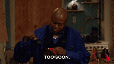 A Man In A Blue Shirt Says Too Soon In Front Of A Netflix Logo GIF