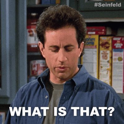 A Man In A Blue Shirt Says What Is That In Front Of A Shelf Of Corn Flakes GIF