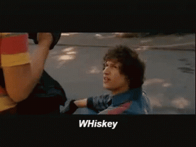 A Man In A Blue Shirt Says Whiskey In A Movie Scene GIF