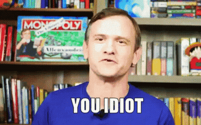 A Man In A Blue Shirt Says You Idiot In Front Of A Bookshelf GIF
