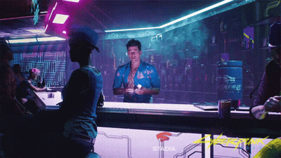 A Man In A Blue Shirt Stands At A Bar With Stadia Written On The Wall Behind Him GIF