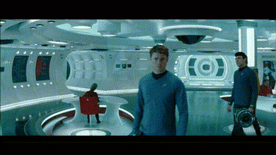 A Man In A Blue Shirt Stands In A Room With A Target On The Wall Behind Him GIF