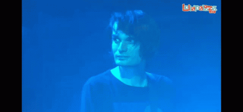A Man In A Blue Shirt Stands In Front Of A Screen That Says Laplaza GIF
