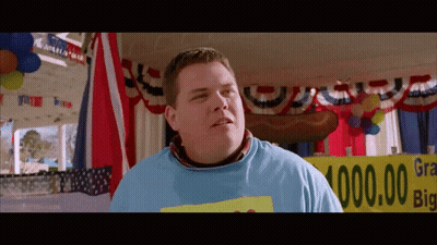 A Man In A Blue Shirt Stands In Front Of A Sign That Says ' Grand Prize ' GIF