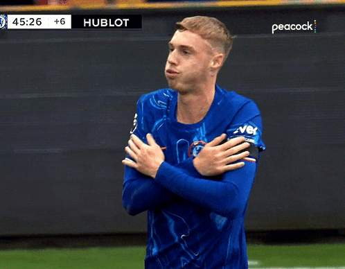 A Man In A Blue Shirt Stands On A Soccer Field With Peacock Written On The Bottom GIF