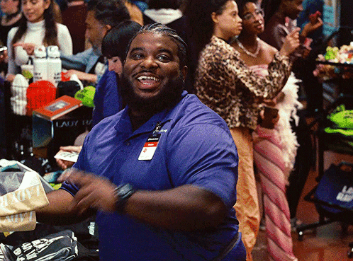 A Man In A Blue Shirt With A Name Tag That Says ' Smith ' On It Is Smiling GIF