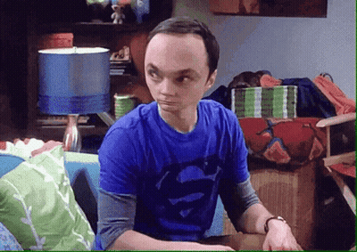 A Man In A Blue Shirt With Superman On It Is Sitting On A Couch GIF