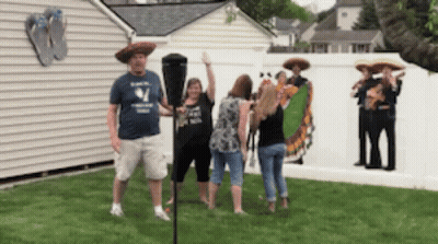 A Man In A Blue Shirt With The Letter W On It Stands Next To A Woman In A Sombrero GIF