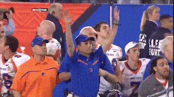 A Man In A Blue Shirt With The Word Florida On It Stands In A Crowd GIF