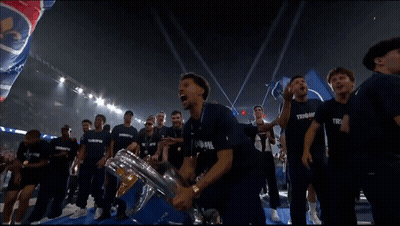A Man In A Blue Shirt With The Word Trophe On It Holds A Trophy GIF