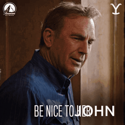 A Man In A Blue Shirt With The Words Be Nice To John GIF