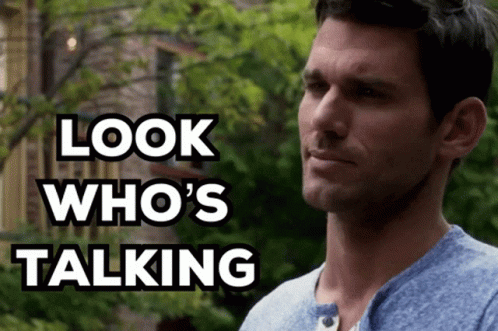 A Man In A Blue Shirt With The Words Look Who 'S Talking Behind Him GIF