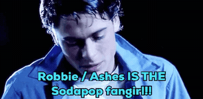 A Man In A Blue Shirt With The Words Robbie / Ashes Is The Sodapop Fangirl Written Below Him . GIF