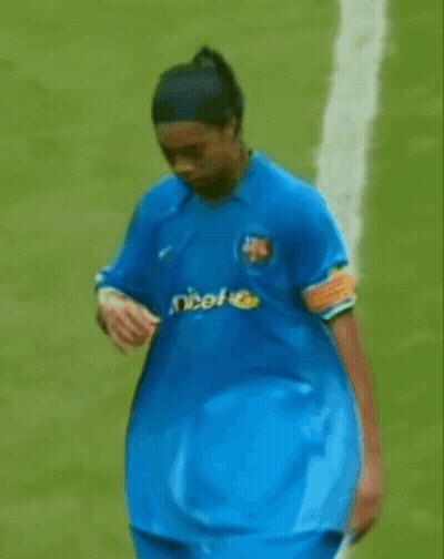 A Man In A Blue Shirt With Unicef On It Is Walking On A Field . GIF