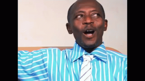 A Man In A Blue Striped Shirt And Tie Is Making A Funny Face GIF