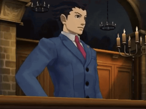 A Man In A Blue Suit And Red Tie Is Standing In Front Of A Chandelier GIF