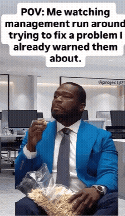 A Man In A Blue Suit And Tie Is Holding A Bag Of Popcorn .. GIF