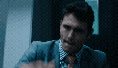A Man In A Blue Suit And Tie Is Making A Funny Face GIF