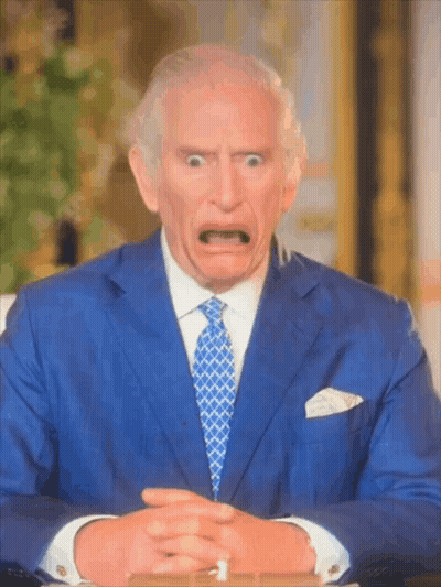 A Man In A Blue Suit And Tie Is Making A Surprised Face GIF
