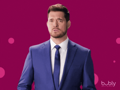 A Man In A Blue Suit And Tie Is Standing In Front Of A Pink Background With The Word Bubly On It GIF